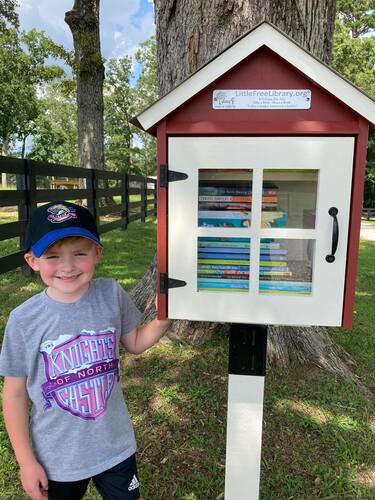 Alex standing next to the WD Farm Little Free Library